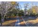 Gravel driveway lined with trees leading to home at 3980 River Rd, Johns Island, SC 29455