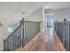 Upper hallway with dark wood flooring and black metal railing at 3980 River Rd, Johns Island, SC 29455