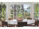 Sunlit dining area with a round table, wicker chairs, and expansive window views at 935 Paul Revere Dr, Charleston, SC 29412