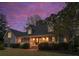 Gray two-story house with a wrap-around porch and well-manicured lawn at sunset at 935 Paul Revere Dr, Charleston, SC 29412