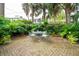 Secluded garden oasis with brick patio and lush tropical plants at 14 1/2 Murray Blvd, Charleston, SC 29401