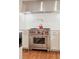 Modern kitchen with stainless steel range and hood, white cabinets and hardwood floors at 14 1/2 Murray Blvd, Charleston, SC 29401