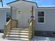 Modern front entrance with white door and wooden stairs, leading to a gray house at 161 Stratton Dr, North Charleston, SC 29420