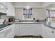 White kitchen cabinets, gray countertops, and a view to the backyard at 174 Winding Rock Rd, Goose Creek, SC 29445