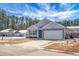 Two-car garage home with gray siding, and a small front yard at 221 Rubles Ln, Moncks Corner, SC 29461