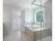 Bright bathroom featuring a tiled shower with glass door and a luxurious soaking tub near the window at 349 Blue Oak Dr, Moncks Corner, SC 29461