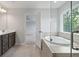 Elegant bathroom featuring a soaking tub, glass shower, tile floors, and double vanity at 349 Blue Oak Dr, Moncks Corner, SC 29461