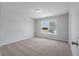 A carpeted empty bedroom with a view from the window, which reveals the neighborhood and the house across at 349 Blue Oak Dr, Moncks Corner, SC 29461