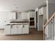 Kitchen featuring white cabinets, a center island, and a staircase, offering a modern and functional design at 349 Blue Oak Dr, Moncks Corner, SC 29461