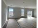 Empty living room with dark hardwood floors and three large windows for natural light at 349 Blue Oak Dr, Moncks Corner, SC 29461