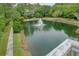 Aerial view of the community pond with a fountain, surrounded by trees and a glimpse of a home at 400 Bay Crossing Rd, Mount Pleasant, SC 29464