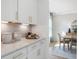 White kitchen with quartz countertops and gold hardware; view of dining area at 472 White Magnolia St, Moncks Corner, SC 29461