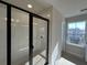 Modern bathroom featuring a glass-enclosed shower with white subway tile and a view from a large window at 5134 Double Eagle, Summerville, SC 29485