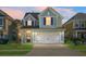 Charming two-story house with a light blue exterior, white garage door, and manicured lawn at 563 Alderly Dr, Moncks Corner, SC 29461