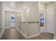 Upstairs hallway with wood floors, white railing, and access to bedrooms at 128 Sandy Bend Ln, Summerville, SC 29486