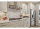 Modern kitchen features white cabinets, herringbone backsplash, and stainless steel appliances at 128 Sandy Bend Ln, Summerville, SC 29486