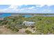 Elevated home with a large deck and stairs, surrounded by trees and water at 153 Dewees Inlet Dr, Dewees Island, SC 29451