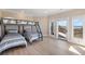 Bedroom with twin beds, bunk bed, hardwood floors, and water views at 153 Dewees Inlet Dr, Dewees Island, SC 29451