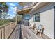 Deck with wooden railing, chairs, and partial ocean view at 153 Dewees Inlet Dr, Dewees Island, SC 29451