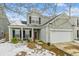 Two-story house with light green siding, white garage door, and a porch at 2005 Isabela Ct, Summerville, SC 29483