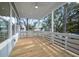 Relaxing covered porch with wood flooring and white railing at 3893 James Bay Rd, Johns Island, SC 29455