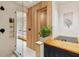 Modern bathroom with glass shower, wooden wall, and view of another bathroom at 3 Chisolm St # 106, Charleston, SC 29401