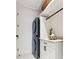 Bright laundry room with modern stacked washer and dryer, white cabinets, and shelving at 3 Chisolm St # 106, Charleston, SC 29401