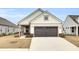 Two-car garage and front porch. White siding and brick accents at 333 Dahlia Row Dr, Summerville, SC 29486