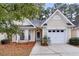 Charming yellow house with a white garage door and landscaping at 4845 Carnoustie Ct, Summerville, SC 29485