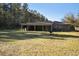 Backyard view of home with covered patio, fire pit and fenced area at 601 Levee Dr, Moncks Corner, SC 29461