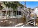 Elevated beach cottage with wrap-around deck and stairs at 613 Pompano St, Edisto Island, SC 29438