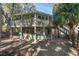 Two-story home with wrap-around deck and stairs at 613 Pompano St, Edisto Island, SC 29438
