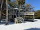 Elevated two-story home with wrap-around decks, stairs, and fenced yard at 613 Pompano St, Edisto Island, SC 29438