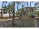 Charming house exterior with a fenced yard and tropical landscaping at 613 Pompano St, Edisto Island, SC 29438