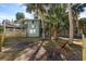 Charming house exterior with a fenced yard and tropical landscaping at 613 Pompano St, Edisto Island, SC 29438