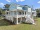 Two-story house with light blue siding, white trim, and a wrap-around porch at 6522 Beagle Club Rd, Meggett, SC 29449