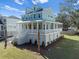 Two-story house with light blue siding, white trim, and a wrap-around porch at 6522 Beagle Club Rd, Meggett, SC 29449