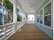 Inviting porch with wooden floors, ceiling fans and white pillars, creating an ideal outdoor relaxation space at 6522 Beagle Club Rd, Meggett, SC 29449