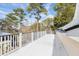 White deck with railings, offering scenic views of the surrounding trees and houses at 7003 Old Landing Dr, Hanahan, SC 29410