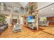 Open living space with hardwood floors, a large TV, and views into the dining area at 975 Mayfield St, Summerville, SC 29485