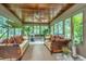 Bright sunroom features wicker furniture, wood ceiling, and lush plants at 975 Mayfield St, Summerville, SC 29485