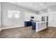 Open concept kitchen with island, white cabinets, and hardwood floors at 105 Waxwing Dr, Summerville, SC 29483