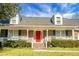 Brick home with red door, white porch, and well-manicured landscaping at 1219 Edward Dr, Moncks Corner, SC 29461