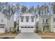 Two-story white house with a two-car garage and landscaping at 155 Surfbird Rd, Summerville, SC 29486