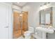 Bathroom with tiled shower, pedestal sink, and decorative mirror at 1681 E Ashley Ave # A & B, Folly Beach, SC 29439
