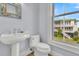 Small bathroom with pedestal sink, toilet, and ocean view at 1681 E Ashley Ave # A & B, Folly Beach, SC 29439