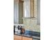 Kitchen detail showing cooktop, range hood, and stylish mosaic backsplash at 1681 E Ashley Ave # A & B, Folly Beach, SC 29439