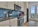 Modern kitchen with ocean view, stainless steel appliances, and blue tile backsplash at 1681 E Ashley Ave # A & B, Folly Beach, SC 29439