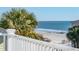 Partial ocean view from balcony with palm trees in foreground at 1681 E Ashley Ave # A & B, Folly Beach, SC 29439