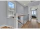 Upstairs hallway with hardwood floors, white railings, and a view from a window at 1681 E Ashley Ave # A & B, Folly Beach, SC 29439